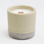 Ceramic candle holder with a textured beige top and concrete base on a white background